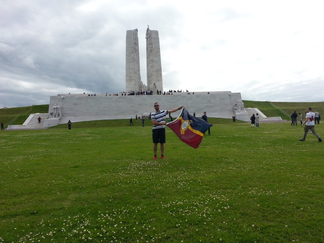 Corporal Duma with the RMR camp flag displayed in front of the Canadian national Vimy monument